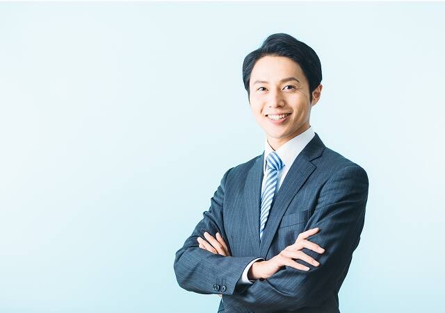 腕を組んでいる男性スタッフ