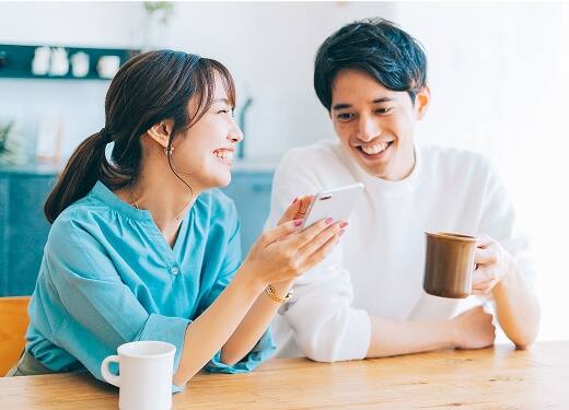 スマホで物件を見ている夫婦