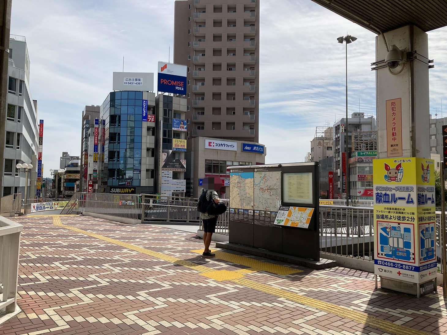南口を出て左手を向くとこのような景色です。周辺地図の看板のすぐ左の通路を渡ります。 