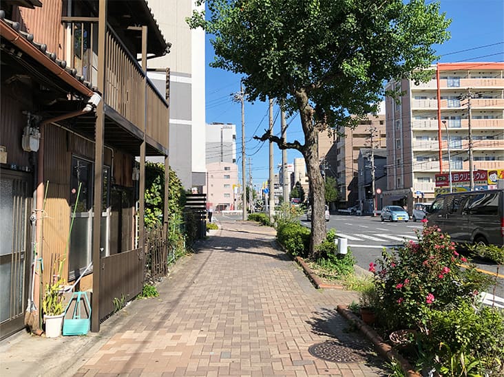 すぐに左手に見える白いマンションの1階が本陣営業センターです。