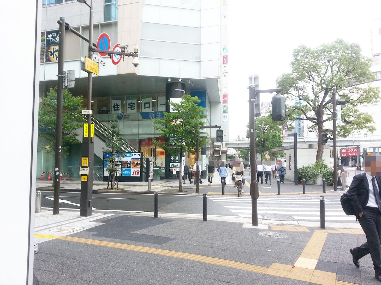 「川崎駅前北」の交差点の横断歩道を渡り、1階のパリミキ（メガネ屋さん）を左手に見ながら直進します。