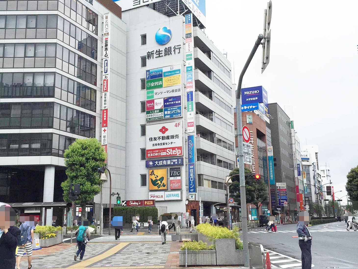 交番の前まできたら、左に見える信号を渡ります。渡った先には、新生銀行やアデランスの看板が見えます。