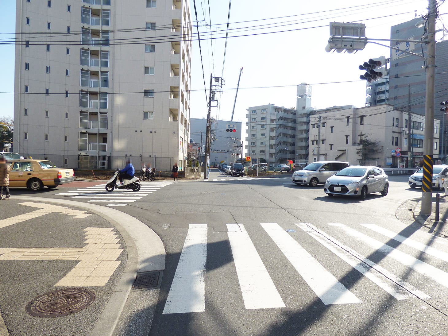 左右に美容室やオリジン弁当、薬局（ハックドラッグ）を見ながら綱島街道まで進み、「綱島」の交差点をまっすぐ向かい側に渡ります。